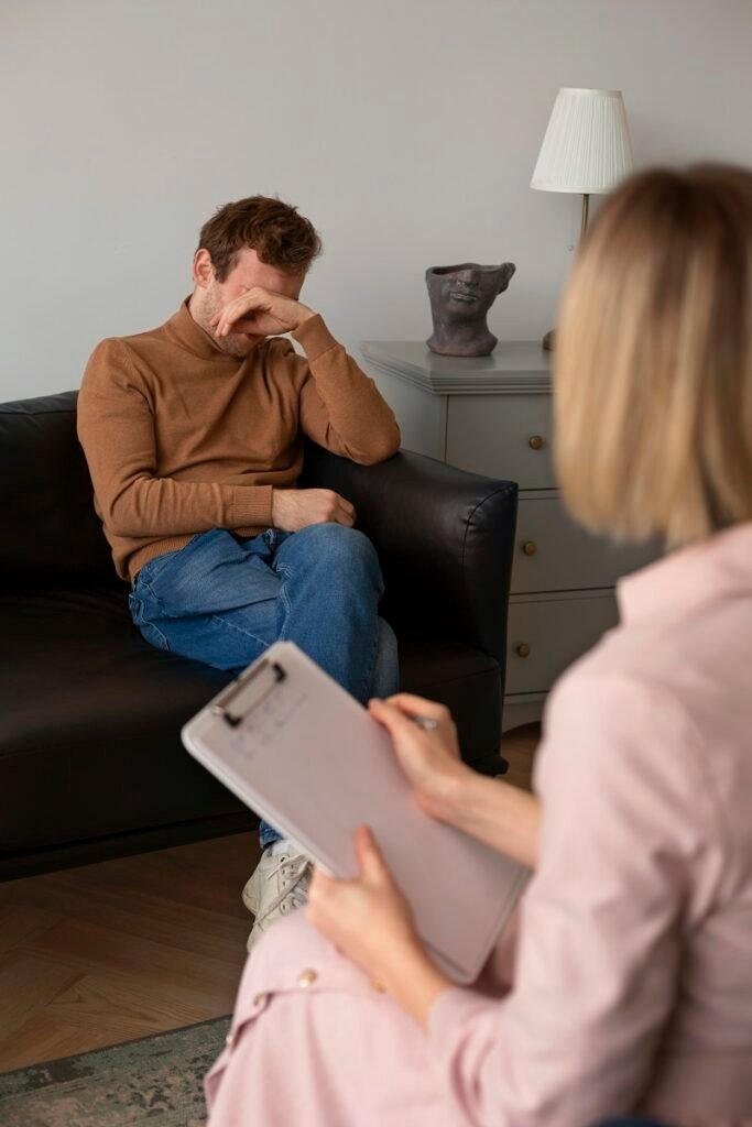 Depressed man sitting on couch during therapy session with counselor showing need for depression treatment and mental health counseling in Bhopal