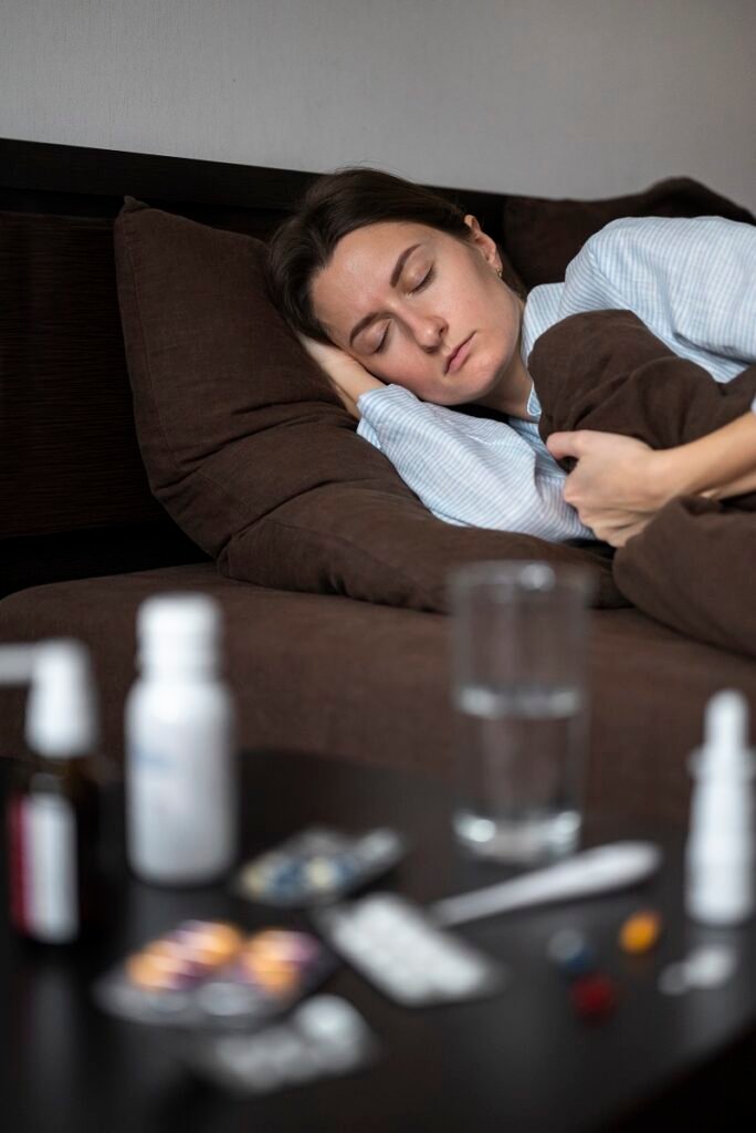 Woman sleeping on bed with medicines on table showing insomnia and sleep problems requiring Insomnia Treatment in Bhopal
