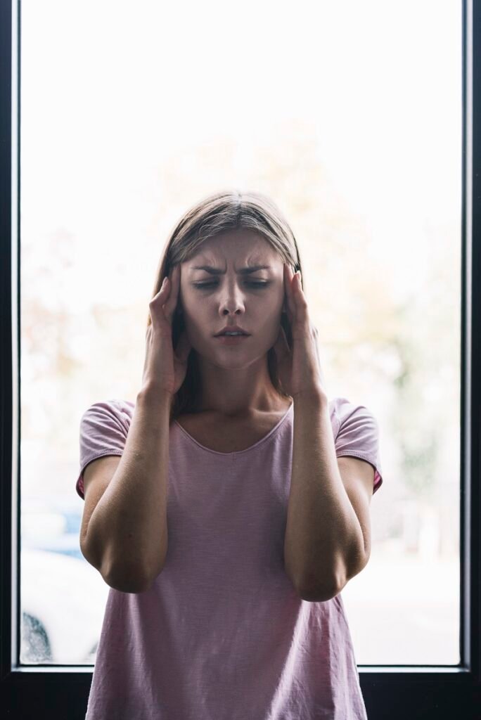 Woman holding her head in pain showing severe stress and anxiety symptoms requiring Anxiety Treatment in Bhopal
