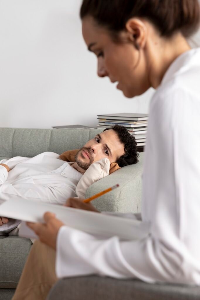 Man lying on couch during therapy session with mental health counselor showing psychological counseling and treatment in Bhopal